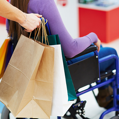 A shopper who is being pushed in a wheelchair