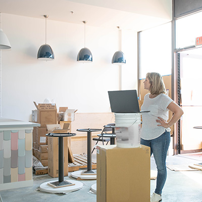 A small business owner looks at the interior of their new shop.